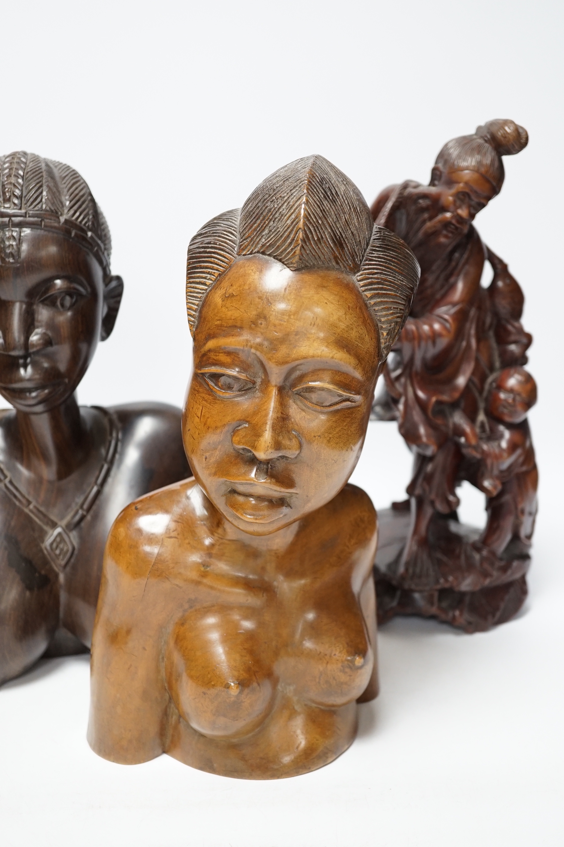 A Chinese carved rootwood figure emblematic of longevity on stand and two carved African busts, Chinese root carving 36cm high